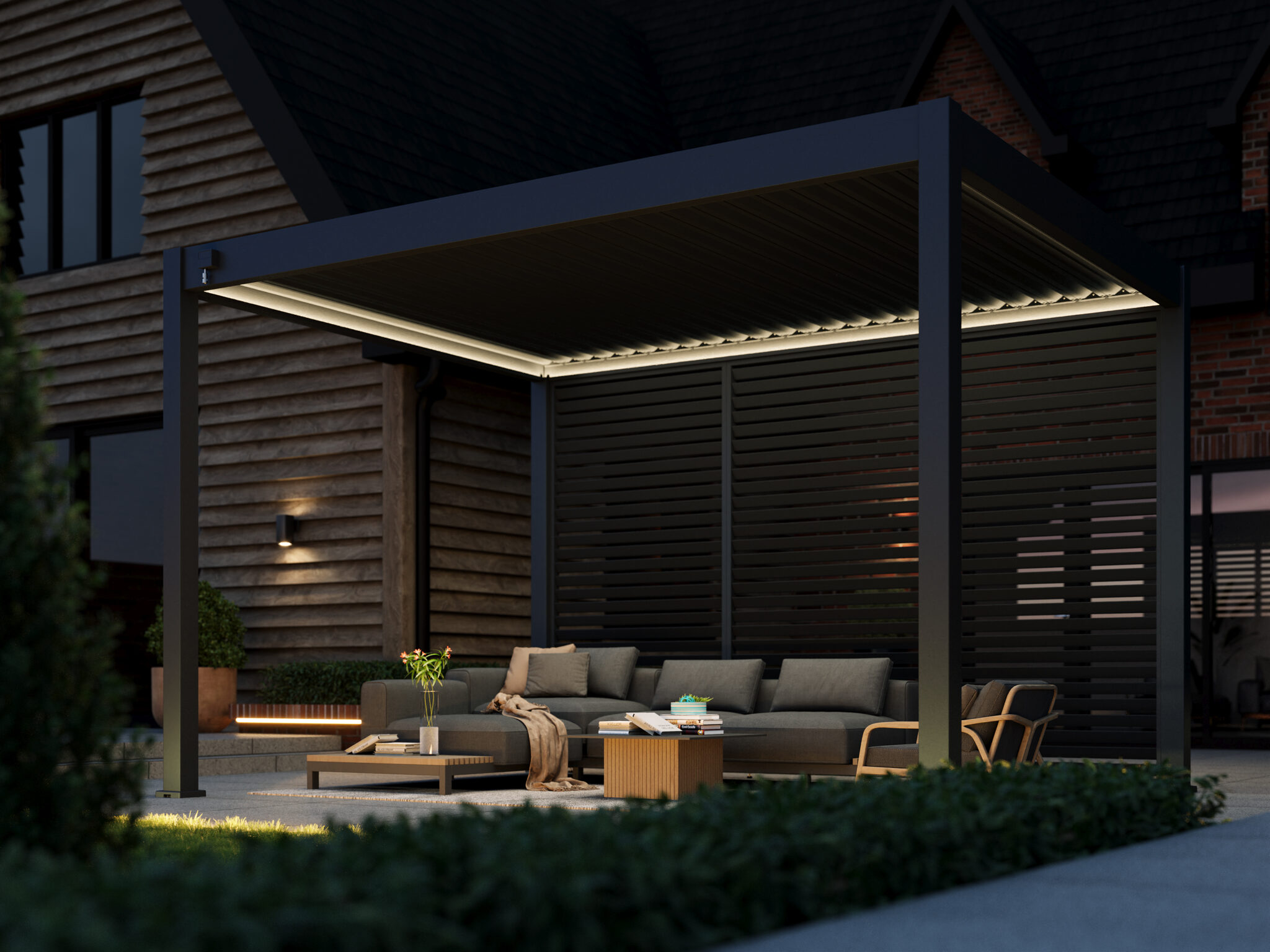 Wall-mounted pergola with LED lighting, placed on a patio next to a dark timber-clad house, featuring a modern lounge set with ambient garden lighting.