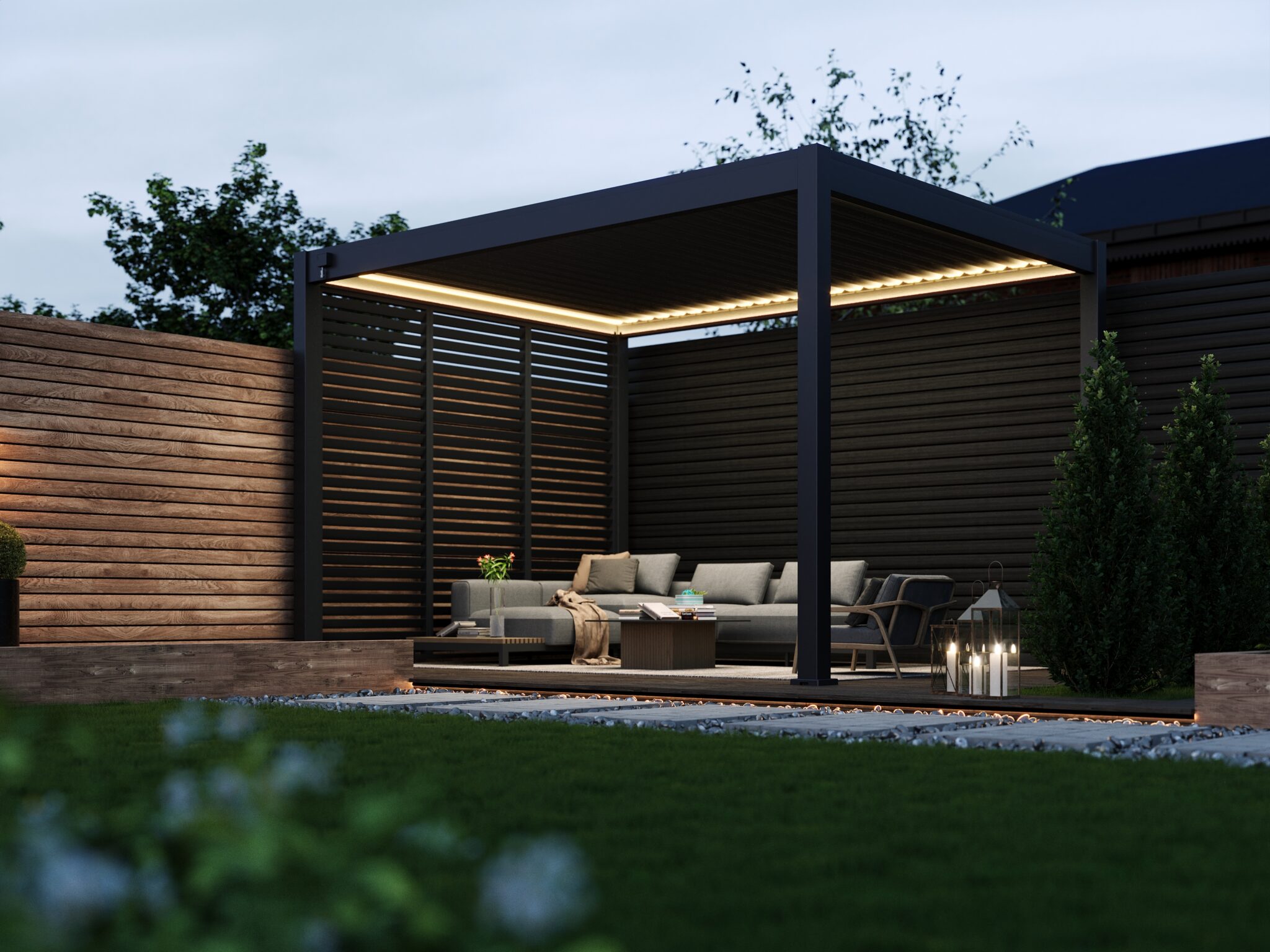 Dark grey pergola with timber privacy panels and LED lighting, installed on a raised deck with rattan sofas and decorative planters in a landscaped garden.