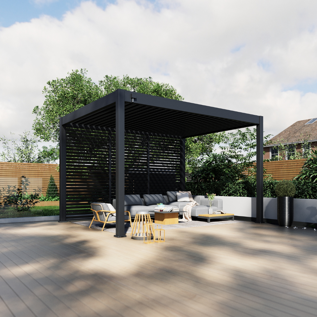 Dark grey pergola with slatted aluminium panels and retractable blinds, styled with cream outdoor sofas, cushions, and decorative lanterns on a composite deck.