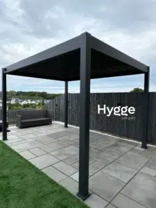Freestanding dark grey aluminium pergola with a sturdy frame, designed for all-weather protection.